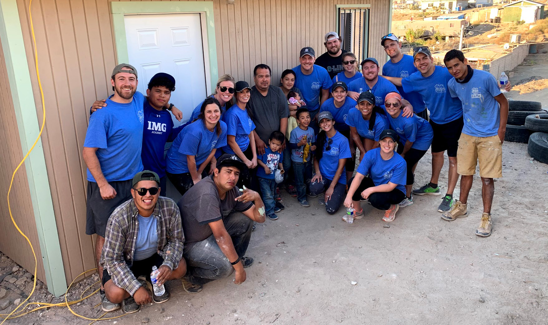 EEU Graduates posing with one of the families we sponsored in front of their newly built house during the 2019 Home-Build trip.