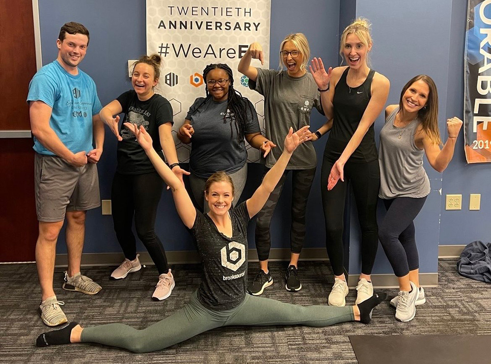 Eight Eleven employees pose after completing a mid-day employee-led pilates class.