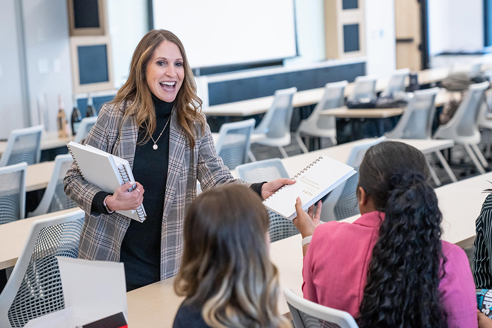 Julia Lindenschmidt, Director of Professional Development, passes out workbooks to employees in the dedicated training room.